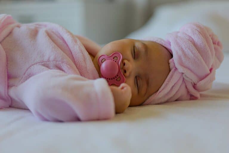 Photo by Simple Soul Photogrphy: https://www.pexels.com/photo/adorable-baby-wearing-pink-robe-and-pacifier-sleeping-27010370/